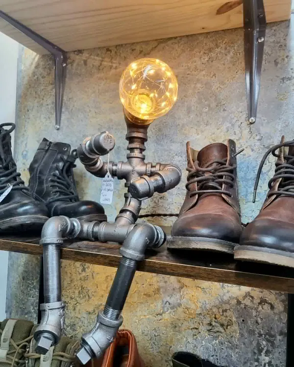 Pipe lamp beside leather boots