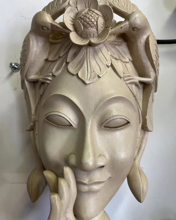 Carved wall mask with a serene face