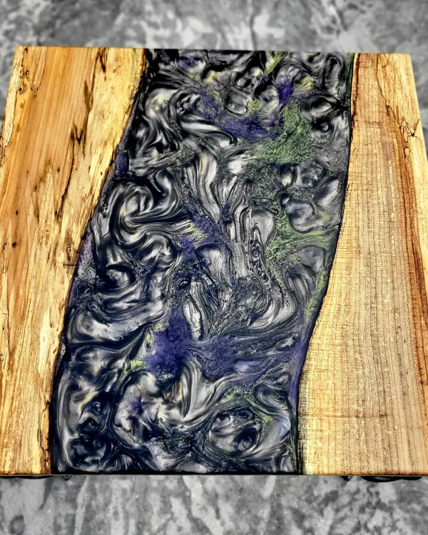 Live-edge serving board with a resin river